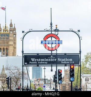 Primo piano di Westminster stazione Undergraound segno con la casa del Parlamento in background. Foto Stock