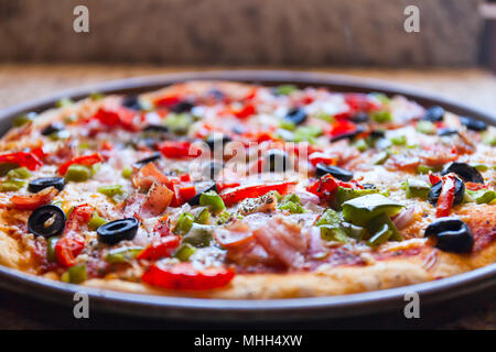 Pane appena sfornato la pizza in una padella. Stile Americano. Una spessa crosta Foto Stock