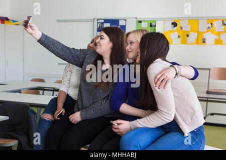 Formazione degli studenti durante la pausa e giocare con i loro smartphone. Foto Stock