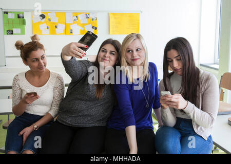 Formazione degli studenti durante la pausa e giocare con i loro smartphone. Foto Stock