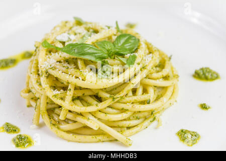 Spaghetti Bucatini con il pesto e il parmigiano da aglio selvatico nel piatto bianco Foto Stock