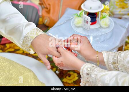 Sposa mette su anello di nozze su groom del dito Foto Stock