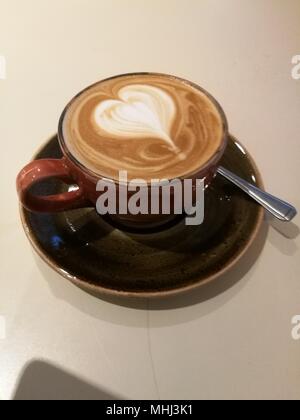 Piatto bianco caffè con pattern su top in schiuma di latte Foto Stock