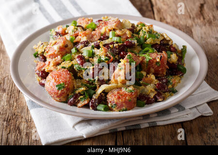 Servire di fagioli rossi con verdi, salsicce, bacon e uova di close-up su una piastra su un piano orizzontale. Foto Stock