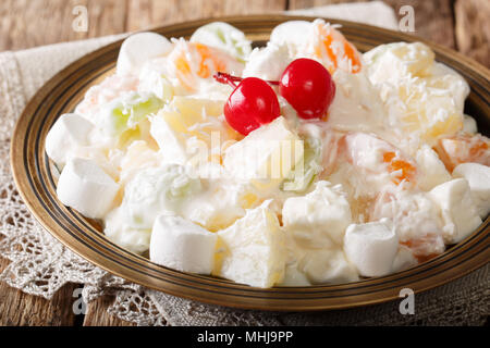 Estate Ambrosia deliziosa insalata di frutta e marshmelow con yogurt alla vaniglia close-up su una piastra orizzontale. Foto Stock