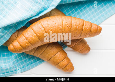 Pane salato rotoli. Croissant integrale sul tovagliolo a scacchi. Foto Stock