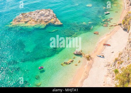 Vista aerea di diverse persone in appoggio sulla selvaggia spiaggia appartata con acque blu turchese sul caldo giorno d'estate e di sole Foto Stock