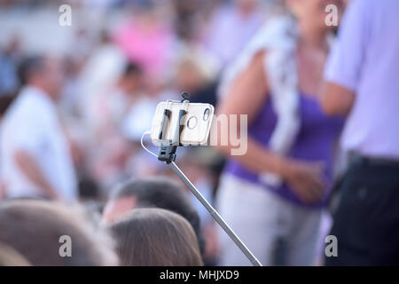 Selfie utilizzando il telecomando e la prolunga treppiede Foto Stock
