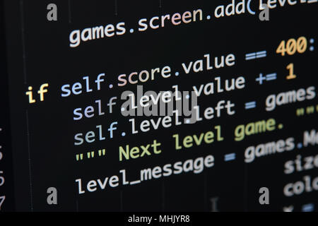 Vero il codice Python sviluppo di schermo. Flusso di lavoro di programmazione algoritmo astratto concetto. Linee di codice Python visibile sotto la lente di ingrandimento. Foto Stock