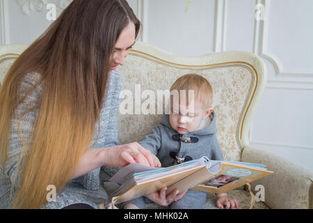 La madre e il suo bambino figlio cerca album fotografico Foto Stock