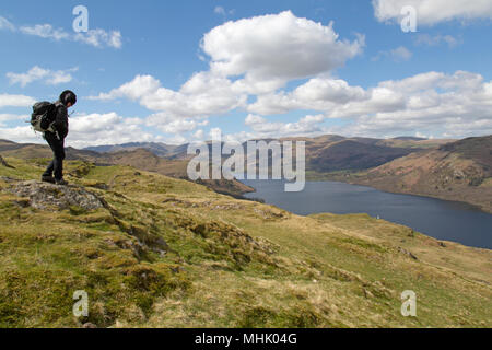 Escursionista femmina su Hallin è sceso vicino Howtown nel Parco nazionale del Lake District in Inghilterra, con Ullswater qui di seguito. Foto Stock