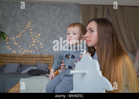 Ritratto di Little Boy in legno cavallo a dondolo Foto Stock