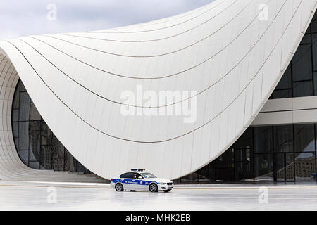 Una BMW auto della polizia passando da Heydar Liyev center di Baku Azarbaijan Foto Stock