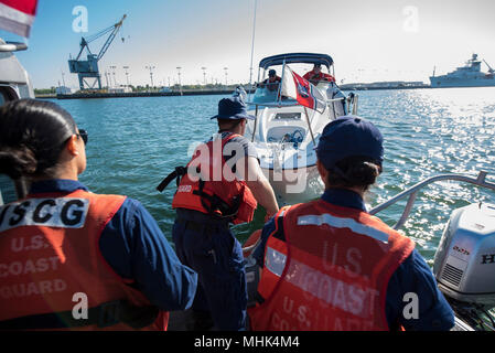 Fireman Trenton Duck ganci a towline per una guardia costiera barca ausiliaria mentre marinaio Suzette Garcia (sinistra) e sottufficiali di terza classe Glover ambra (a destra), un boatswain compagno del monitor, durante un traino di esercizio alla Stazione della Guardia Costiera Port Canaveral Marzo 15, 2018 a Port Canaveral, Florida. Stazione Port Canaveral boatcrews condurre attività di formazione regolarmente per mantenere le qualifiche e per insegnare ai nuovi membri. (U.S. Coast Guard Foto Stock