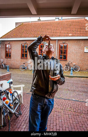 Una sana tradizione di mangiare un aringa cruda come uno snack o un pasto gourmet per essere goduta da i vecchi e i giovani in Urk nei Paesi Bassi Foto Stock