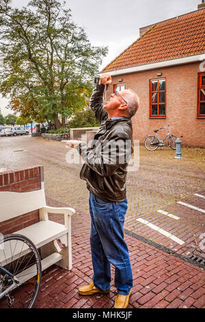 Una sana tradizione di mangiare un aringa cruda come uno snack o un pasto gourmet per essere goduta da i vecchi e i giovani in Urk nei Paesi Bassi Foto Stock