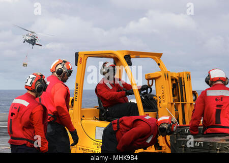 OCEAN (26 marzo 2018) velisti assegnati alle armi dipartimento trasporti inesplosi sul ponte di volo dell'Nimitz-class portaerei USS Abraham Lincoln (CVN 72) durante un rifornimento in corso e le munizioni di onload con la Nimitz-class portaerei USS George H.W. Bussola (CVN 77) ed il veloce combattere la nave appoggio USNS alimentazione (T-AOE 6). (U.S. Navy Foto Stock