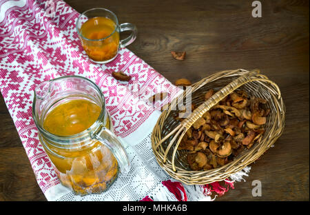 Sul tavolo c'è un decanter e una tazza di confettura di albicocche conserva. In prossimità del cesto con mele disidratate. Foto Stock