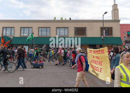 MINNEAPOLIS - 1 maggio: lavoratori sul tetto guarda su come gli individui di marzo nella Internazionale dei Lavoratori giorno Marzo, ospitato da un certo numero di organizzazioni comunitarie e le organizzazioni sindacali dei lavoratori. Credito: Nicholas Neufeld/Alamy Live News Foto Stock