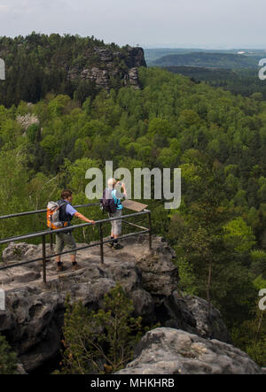 24 aprile 2018, Germania, Papstdorf: Due escursionisti godetevi la vista dal punto di visualizzazione Papststein sulla tabella montagne in Svizzera sassone. Il transfrontaliero percorso trekking 'Forststeig Elbsandstein' in Sassone e della Svizzera boema sarà ufficialmente inaugurato il 28 aprile. Foto: Monika Skolimowska/dpa-Zentralbild/ZB Foto Stock