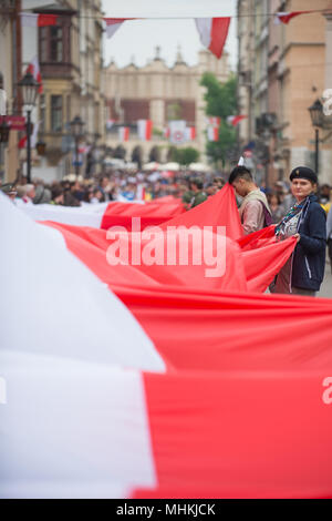 Cracovia in Polonia. Il 2 maggio, 2018. Le persone in possesso di una bandiera polacca lungo la strada reale durante la bandiera nazionale giornata presso la Piazza Principale di Cracovia. Città scout, oggi tentare di rompere il record nazionale lungo la lunghezza della bandiera nazionale. Una bandiera polacca con 3 metri di larghezza e oltre due chilometri di occupare tutta la strada reale, dalla Porta di Florian al colle di Wawel. Credito: Omar Marques/SOPA Immagini/ZUMA filo/Alamy Live News Foto Stock