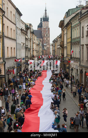 Cracovia in Polonia. Il 2 maggio, 2018. Le persone in possesso di una bandiera polacca lungo la strada reale durante la bandiera nazionale giornata presso la Piazza Principale di Cracovia. Città scout, oggi tentare di rompere il record nazionale lungo la lunghezza della bandiera nazionale. Una bandiera polacca con 3 metri di larghezza e oltre due chilometri di occupare tutta la strada reale, dalla Porta di Florian al colle di Wawel. Credito: Omar Marques/SOPA Immagini/ZUMA filo/Alamy Live News Foto Stock