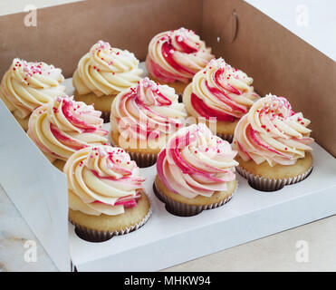 Delicati tortini alla vaniglia con crema nella casella su sfondo bianco Foto Stock