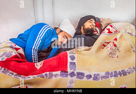 Pellegrini (Amici) sonno, dopo un faticoso viaggio, all'interno del tempio d'oro, Amritsar Punjab, India Foto Stock