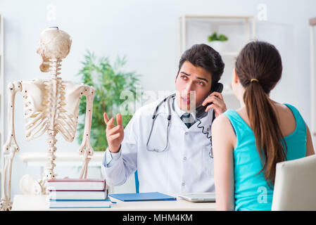 Medico che mostra il tipo di pregiudizio su scheletro al paziente Foto Stock