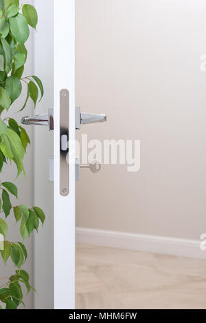 Primo piano della serratura con la chiave. Moderne maniglie cromate. Luce a parete con spazio libero in background Foto Stock