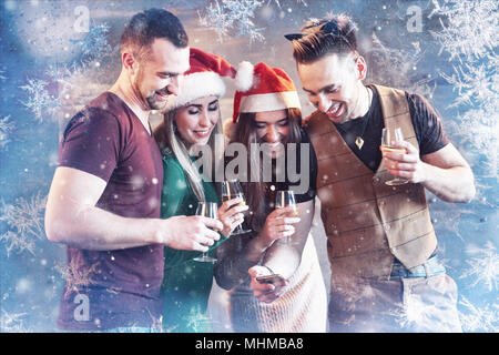 Allegro vecchi amici di comunicare gli uni con gli altri e guardare telefono, con bicchieri di champagne in festa di capodanno. Concetto di intrattenimento e stile di vita. Wifi connesso persone Foto Stock