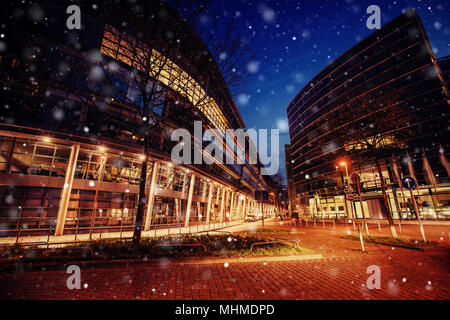 Panorama della città di notte di Dusseldorf in inverno durante una tempesta di neve. Bokeh effetto di luce, filtro morbido Foto Stock