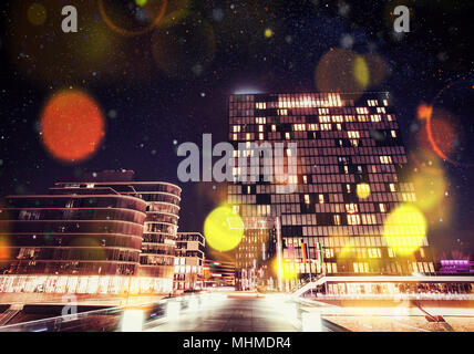 Panorama della città di notte di Dusseldorf in inverno durante una tempesta di neve. Bokeh effetto di luce, filtro morbido Foto Stock