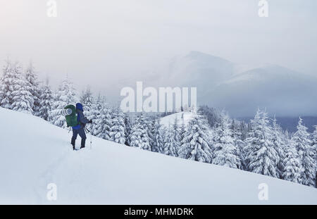 Escursioni con le racchette da neve walker in esecuzione in polvere di neve con bellissima alba luce. Outdoor attività invernali e uno stile di vita sano Foto Stock