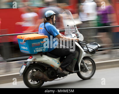 Belgrado, Serbia- Aprile 24, 2018:l'uomo da città consegnato tramite corriere a cavallo di uno scooter su strada trafficata Foto Stock