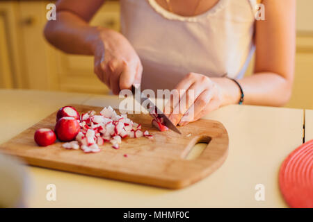 Close up had di una donna cuting ravanelli Foto Stock