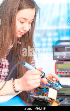 Schoolgirl in robot di laboratorio microcontrollore di debug Foto Stock