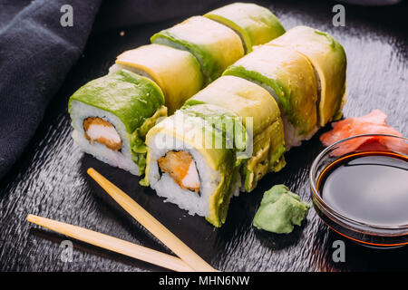 Sushi rullo rivestito con Avocado servito con wasabi e zenzero Foto Stock