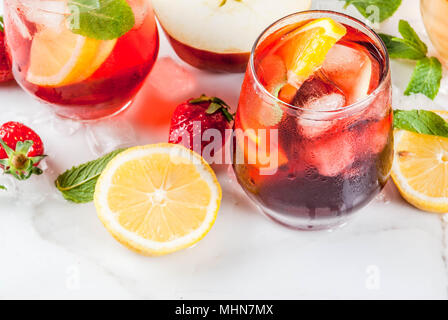 Bianco freddo, rosa e rosso sangria cocktail con frutta fresca e bacche e foglie di menta. Foto Stock
