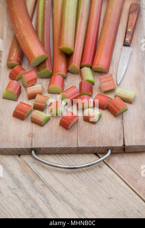 Rheum rhabarbarum. Di rabarbaro tagliato su una tavola di legno Foto Stock