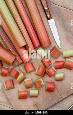 Rheum rhabarbarum. Di rabarbaro tagliato su una tavola di legno Foto Stock