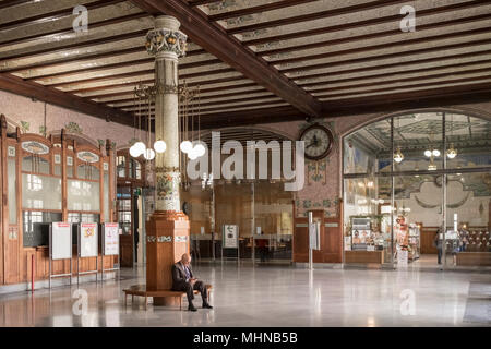 Un uomo anziano si siede da solo in attesa in interni ornati di Estacion del Norte (Nord Station), Sud Ciutat Vella distretto, Valencia, Spagna Foto Stock