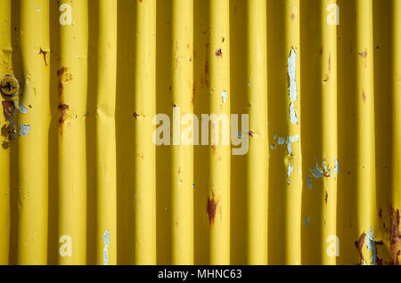 Weathered giallo ondulato metallo arrugginito parete, abstract background. Foto Stock