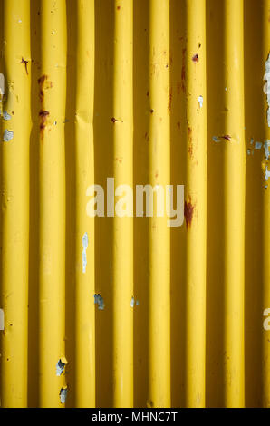 Weathered giallo ondulato metallo arrugginito parete, abstract background. Foto Stock