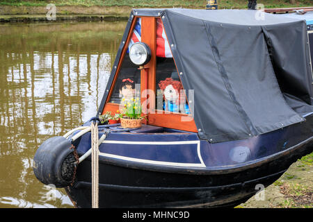 In vecchio stile canal narrowboat con una copertura a telone. In Macclesfield canal la barca stretta ha un telone tetto coperto. I giocattoli sono in Windows Foto Stock