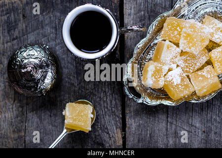 Turkish Delight - gustoso lokum arancione e il caffè turco su sfondo di legno Foto Stock