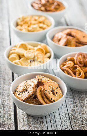 Miscelati snack salato di cracker e salatini nella ciotola. Foto Stock