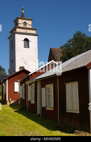 Eredità di Mondo Gammelstad il cottage di chiesa in chiesa per la città con la torre dell orologio a Nederluleå chiesa in background. Foto Stock