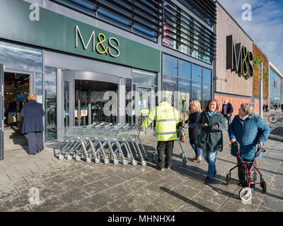 2 febbraio 2018: York, Regno Unito - Un M&S dipendente in una alta vis vest, che lavorano al di fuori del negozio alla Vangarde Shopping Centre, i monaci Croce e sho femmina Foto Stock