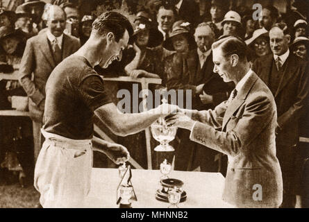 Albert, il Duca di York (più tardi re George VI 1895-1952) nella foto di aggiudicazione del Duca di York's Cup a suo cugino e capitano della marina militare vittorioso team, Lord Louis Mountbatten (1° Conte Mountbatten di Birmania 1900-1979) al polo annuale match tra la Royal Air Force e la Royal Navy in Ranelagh nel luglio 1933. Data: 1933 Foto Stock